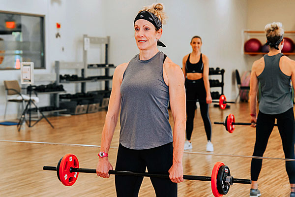 Fitness instructor using weights in a fitness class in the exercise studios at Steel Fitness Premier.