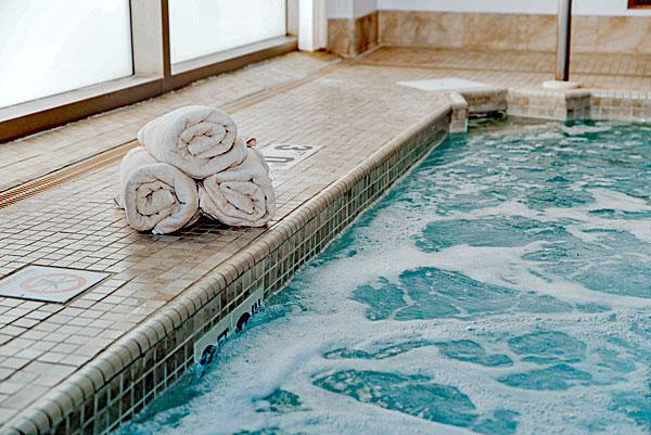 Three rolled up towels next to the jacuzzi in the Steel Fitness Premier spa.