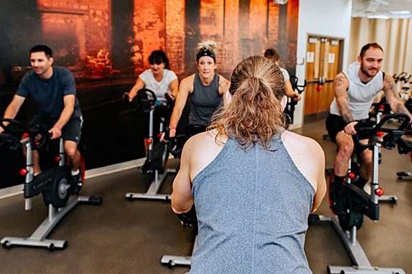 Instructor leading a spin class in the cycle studio at Steel Fitness Premier.