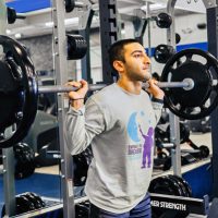Man doing squats using a squat rack at Steel Fitness Premier.