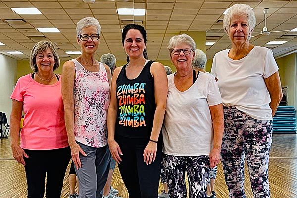 Five women ready to work out and take an exercise class for seniors at Steel Fitness Premier.