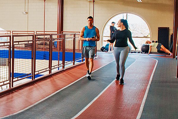 Woman and man walking on the Steel Fitness Premier indoor track.